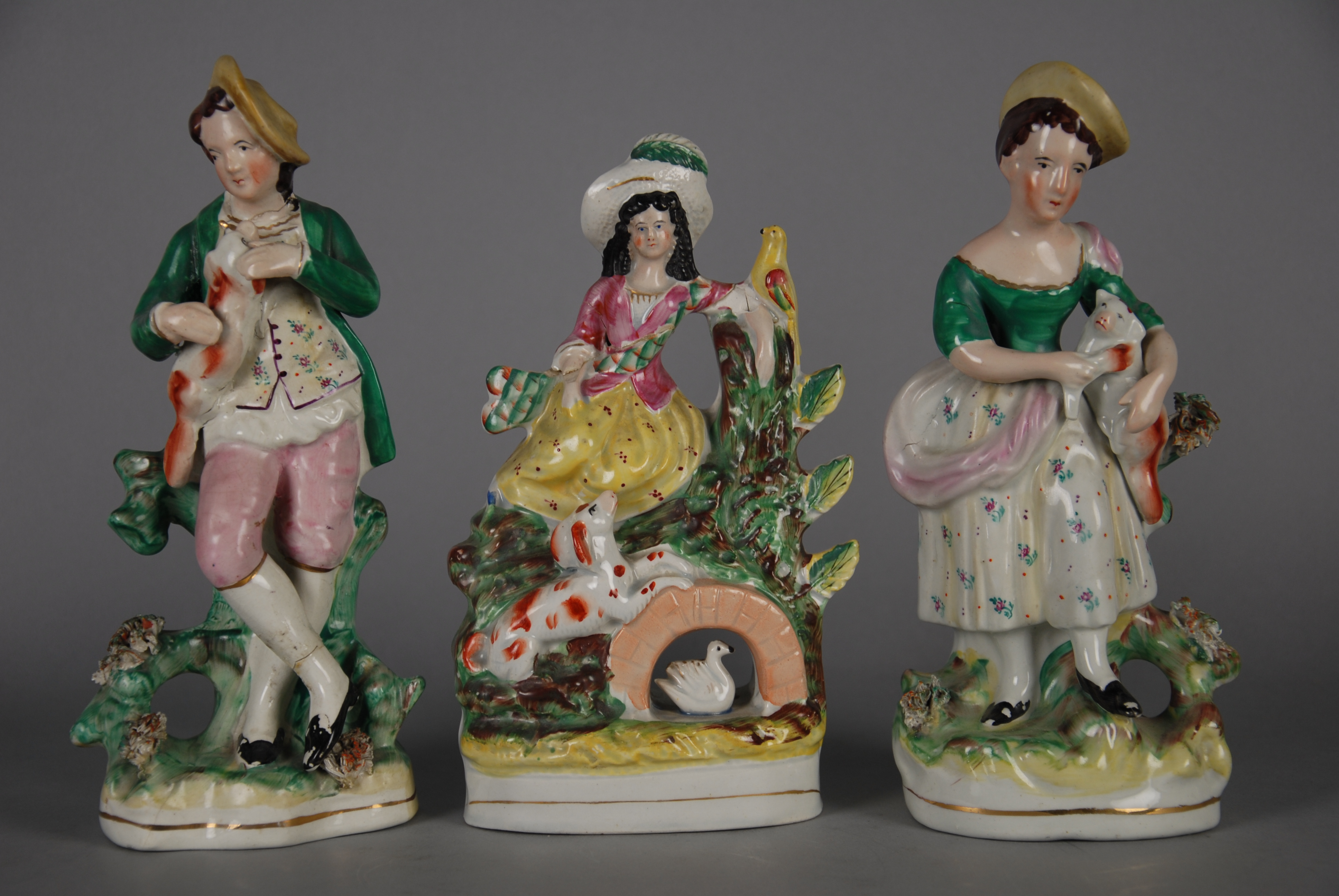 Tre sculture in porcellana policroma raff. ''PERSONAGGI''. XIX secolo. Difetti. Mis. Alt. cm. 24 ca.