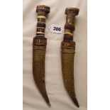 PAIR OF EASTERN DAGGERS WITH CURVED BLADE WITH STAINED HORN AND BONE HILTS 16CM BLADE