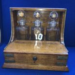 OAK AND BRASS BANDED THREE BOTTLE TANTALUS,