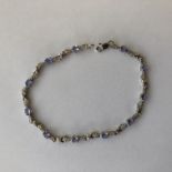 STAMPED 10K WHITE GOLD AND TANZANITE TENNIS BRACELET 6.