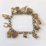 9CT GOLD BRACELET WITH VARIOUS CHARMS AND HEART PADLOCK CLASP 28.