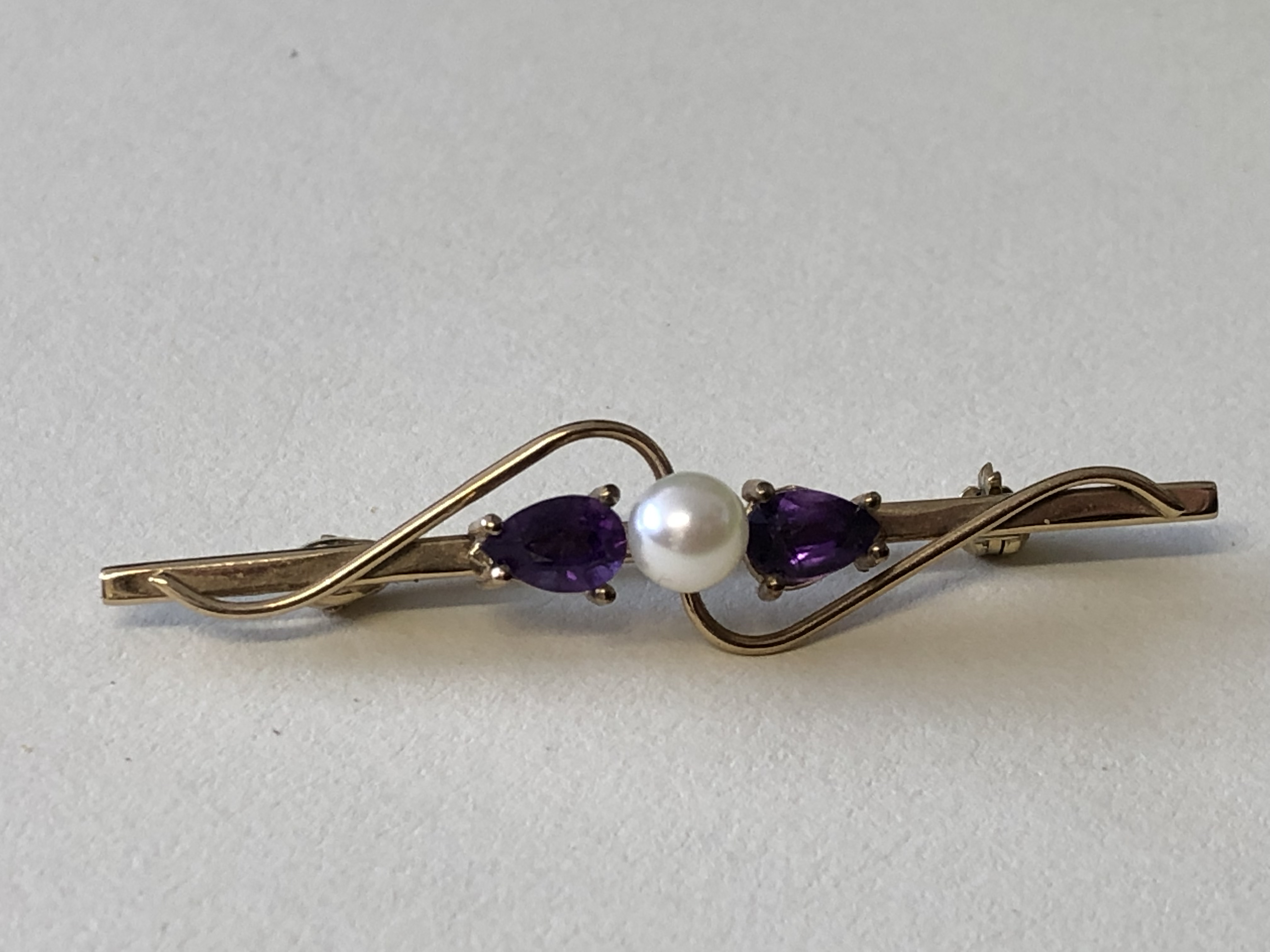 9CT YELLOW GOLD BAR BROOCH SET WITH A CULTURED PEARL FLANKED BY CLAW SET AMETHYSTS 2. - Image 4 of 4