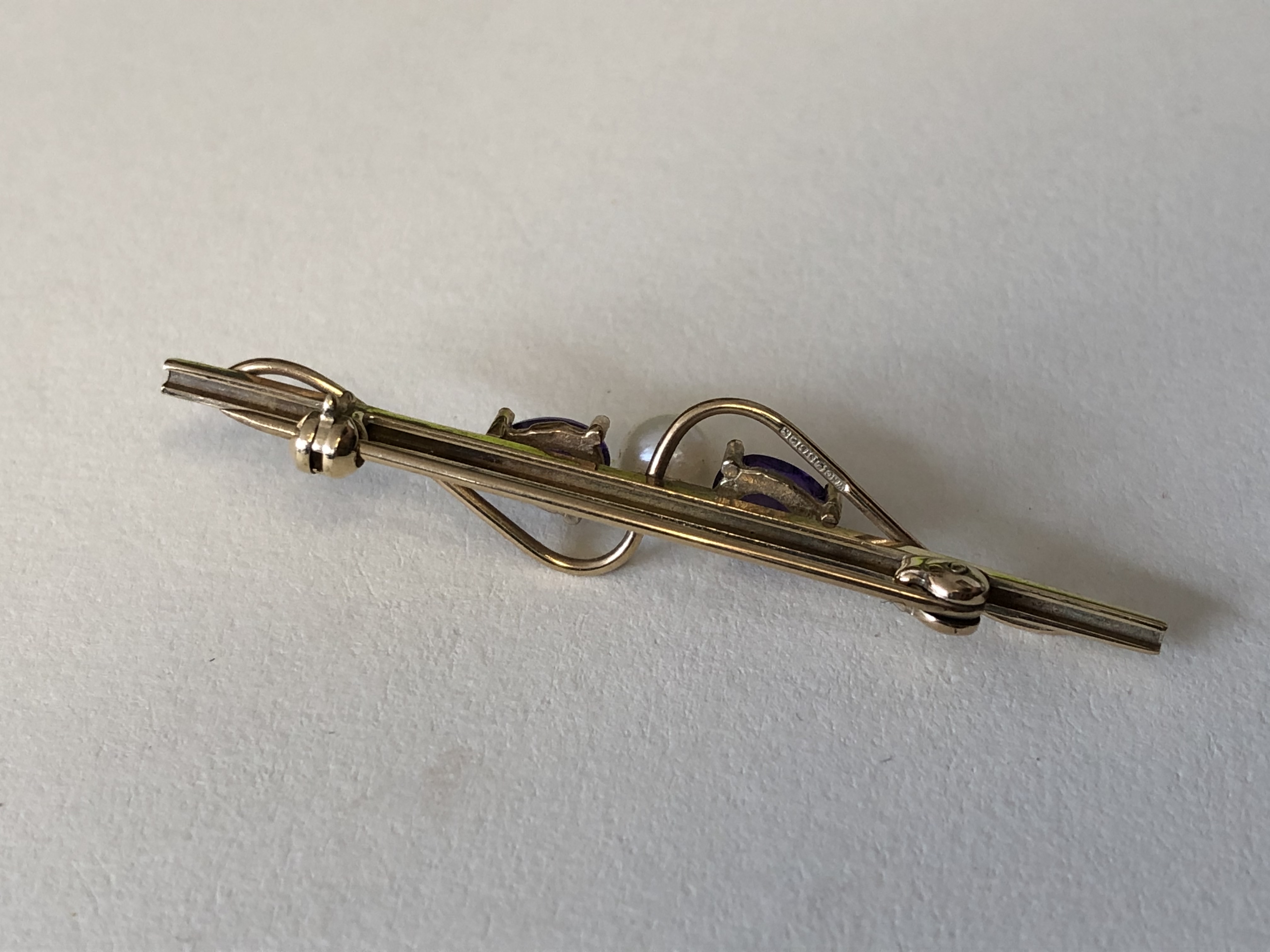 9CT YELLOW GOLD BAR BROOCH SET WITH A CULTURED PEARL FLANKED BY CLAW SET AMETHYSTS 2. - Image 2 of 4