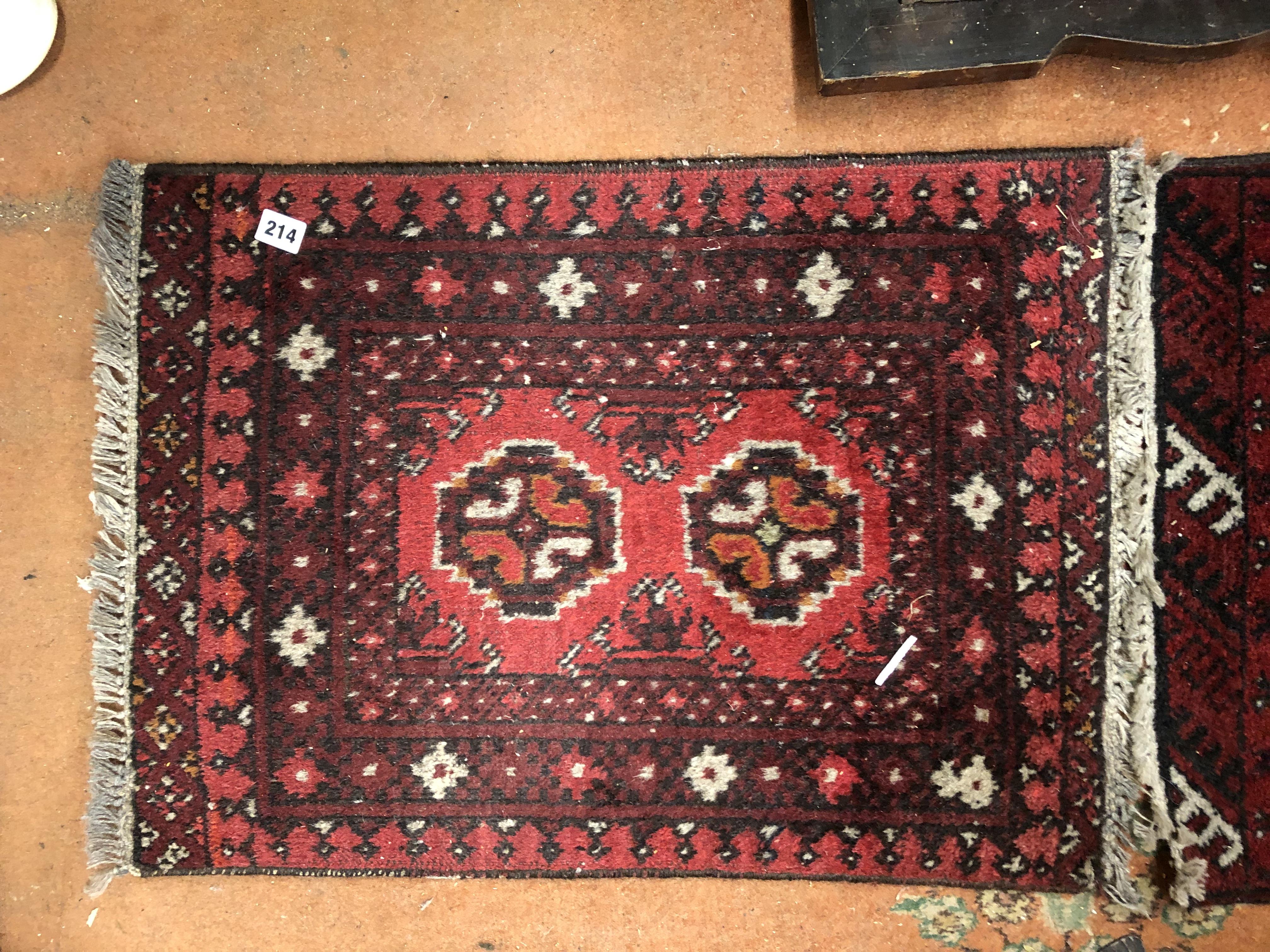 TWO LATE 20TH CENTURY SMALL RUGS ON RED GROUND, - Image 2 of 3