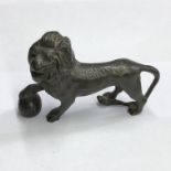 BRONZE FIGURE OF A LION WITH FRONT PAW RESTING ON A BALL