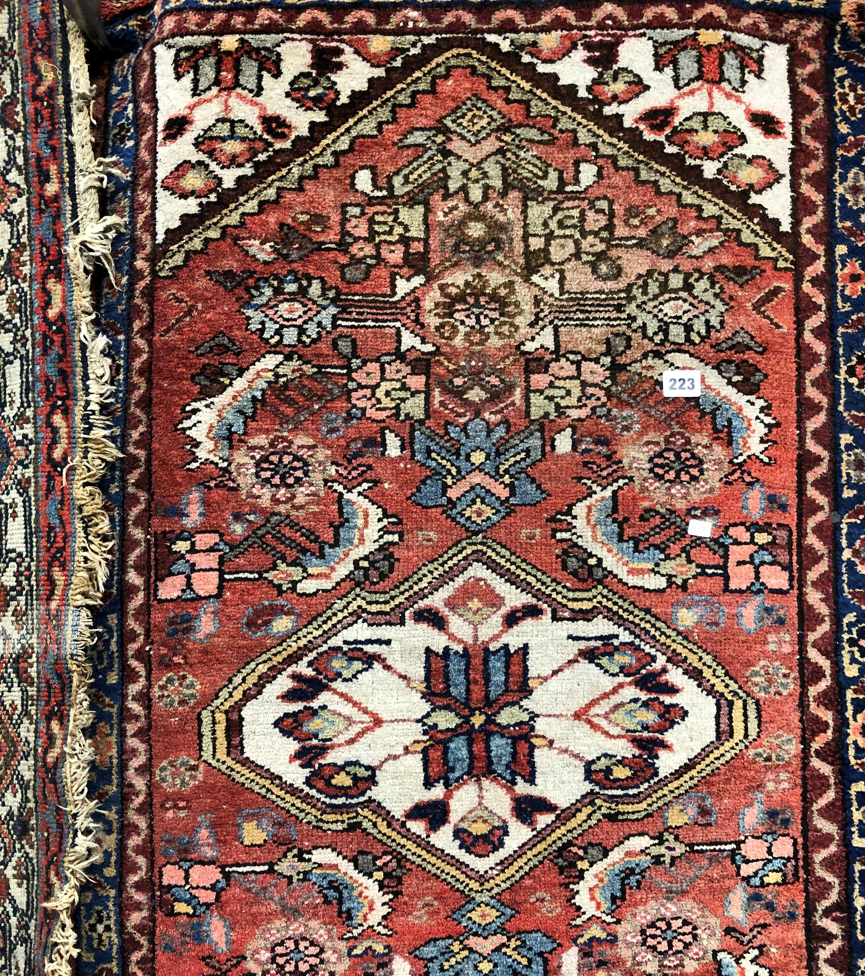 EARLY 20TH CENTURY CAUCASIAN RUG HAVING CENTRAL MEDALLION ON A RED AND BLUE GROUND 83CM X 130CM