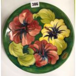MOORCROFT POTTERY PLATE HIBISCUS PATTERN ON A GREEN GROUND 26CM DIA APPROX