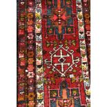 CAUCASIAN RUG ON A RED GROUND 74CM X 300CM APPROX