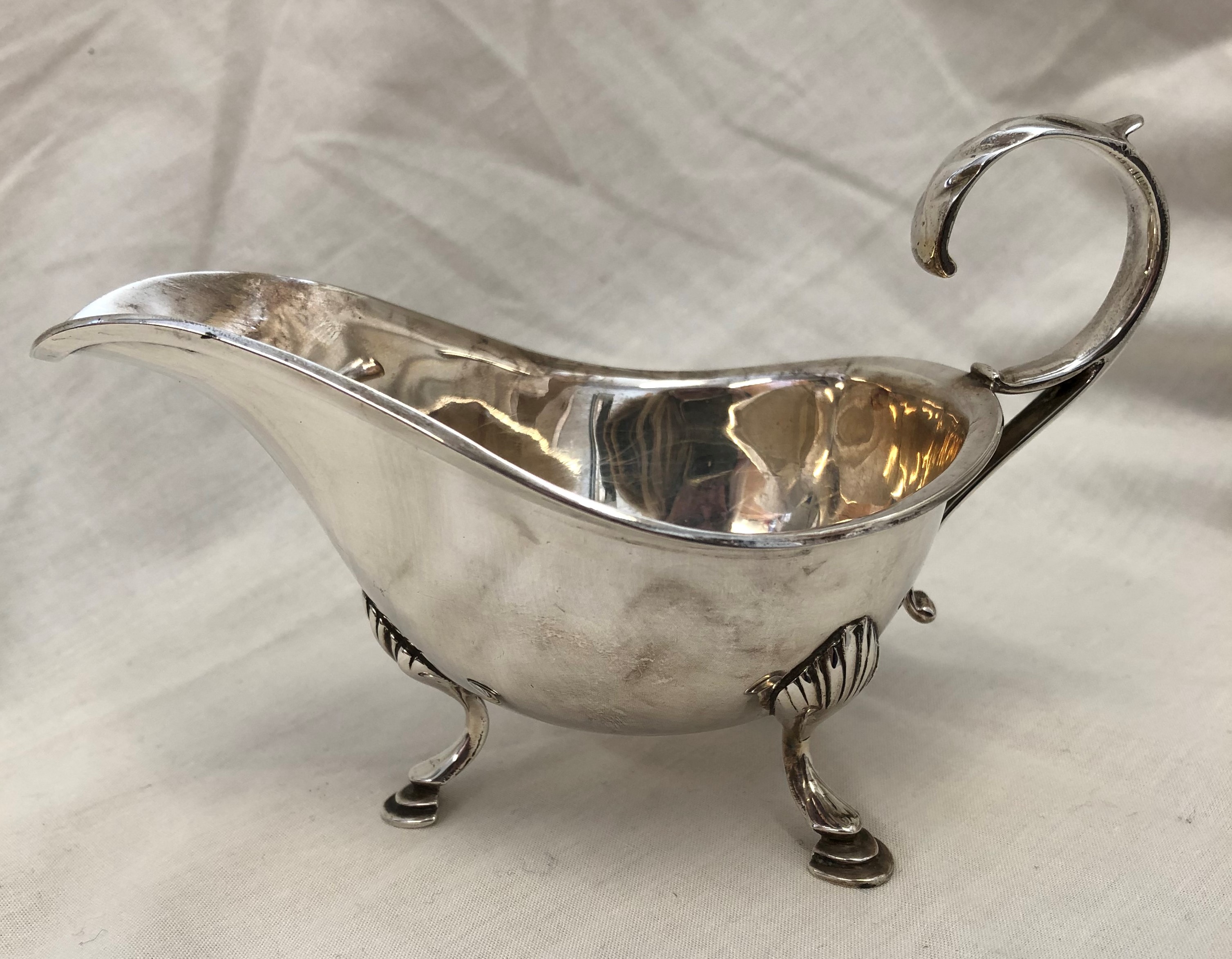 SILVER SAUCE BOAT WITH OPEN SCROLL HANDLE RAISED ON CABRIOLE LEGS WITH PAD FEET, 3.3OZ APPROX.