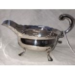 SILVER SAUCE BOAT WITH LEAF CAPPED SCROLL HANDLE RAISED ON PAD FEET, LONDON, HALLMARKS INDISTINCT,