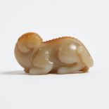 A Pale Celadon and Russet Jade Carving of a Lion, 青白玉帶皮臥獅, length 2.5 in — 6.3 cm