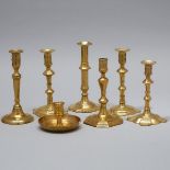 Six Mainly English Brass Candle Sticks and a Chamber Stick, early 18th century, tallest height 8.5 i