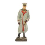 A Lineol figure of Field Marshal Hindenburg. Standing in grey winter greatcoat with cap and sword.