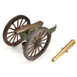 A model cannon, brass barrel 6½” with elevating screw, wooden carriage, iron bound wheels, with