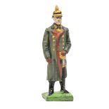A Lineol figure of Field Marshal Hindenburg. Standing in grey winter greatcoat with pickelhaube