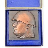 A small rectangular bronze plaque, embossed with a bust of Mussolini wearing a steel helmet and