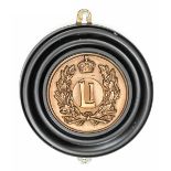 A circular cast brass badge of HM Submarine L1, showing “L1” monogram within an oak wreath and