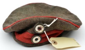 A WWI style Prussian cap, feldmutz, of field grey with crimson band and piping and national and