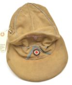 A Third Reich pale khaki soft visored cap, with blue/grey embroidered eagle, cockade on light