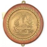 A cast brass circular badge of HMS Tilbury, destroyer 1918-31, showing a cannon on trophy of