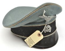 A Third Reich Waffen SS NCO’s vizor cap, with felt band, white piping, grey metal eagle and skull,