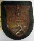 A Third Reich Kuban arm shield, of bronzed zinc on field grey cloth patch with backing plate and