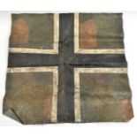 A fabric square purporting to be from a WWI German aircraft, painted with a black and white cross on