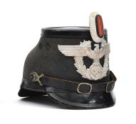 A Third Reich Berlin police shako, of black fibre with patent leather trim, aluminium eagle badge