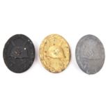 Three Third Reich wound badges: gold with solid back and "L/14" maker's code; grey metal with