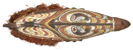 A New Guinea (Sepik river area) wooden shield. Of elliptical form and carved with a stylised human