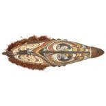 A New Guinea (Sepik river area) wooden shield. Of elliptical form and carved with a stylised human