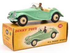 A Dinky Toys M.G. Midget Sports 102. Pale green body, cream interior and wheels. With grey suited