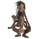 An African carved darkwood double figure, one seated on the shoulders of the other squatting figure,