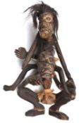 An African carved darkwood double figure, one seated on the shoulders of the other squatting figure,