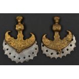 A pair of decorative Indian axe heads. 8cms, cast and pierced serrated steel blades, cast brass
