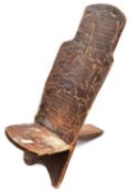 An African child's (?) chair, formed from 2 panels of wood which slot together in the centre, the