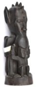An African carved darkwood figure of a double deity, the top figure's head with pointed ears and row