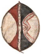 An African hide shield, of ovoid form, wooden frame with central grip, red, white and black (