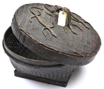 An African raffia woven circular casket, on squared base, the lid decorated with 3 lizards, the
