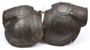 A near pair of pauldrons from late 16th century European armour, with turned over roped edges,