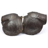 A near pair of pauldrons from late 16th century European armour, with turned over roped edges,