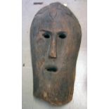 A large hollow, carved human head, in the form of a mask with cut out eyes, long nose and cut out