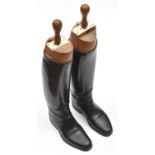 A pair of officers knee length boots, fitted wooden trees, the tops with ivorine labels with maker's