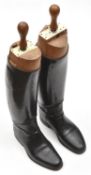 A pair of officers knee length boots, fitted wooden trees, the tops with ivorine labels with maker's