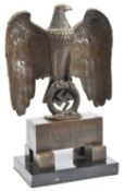 An impressive Third Reich desk ornament, in the form of a bronze eagle and swastika resting on an
