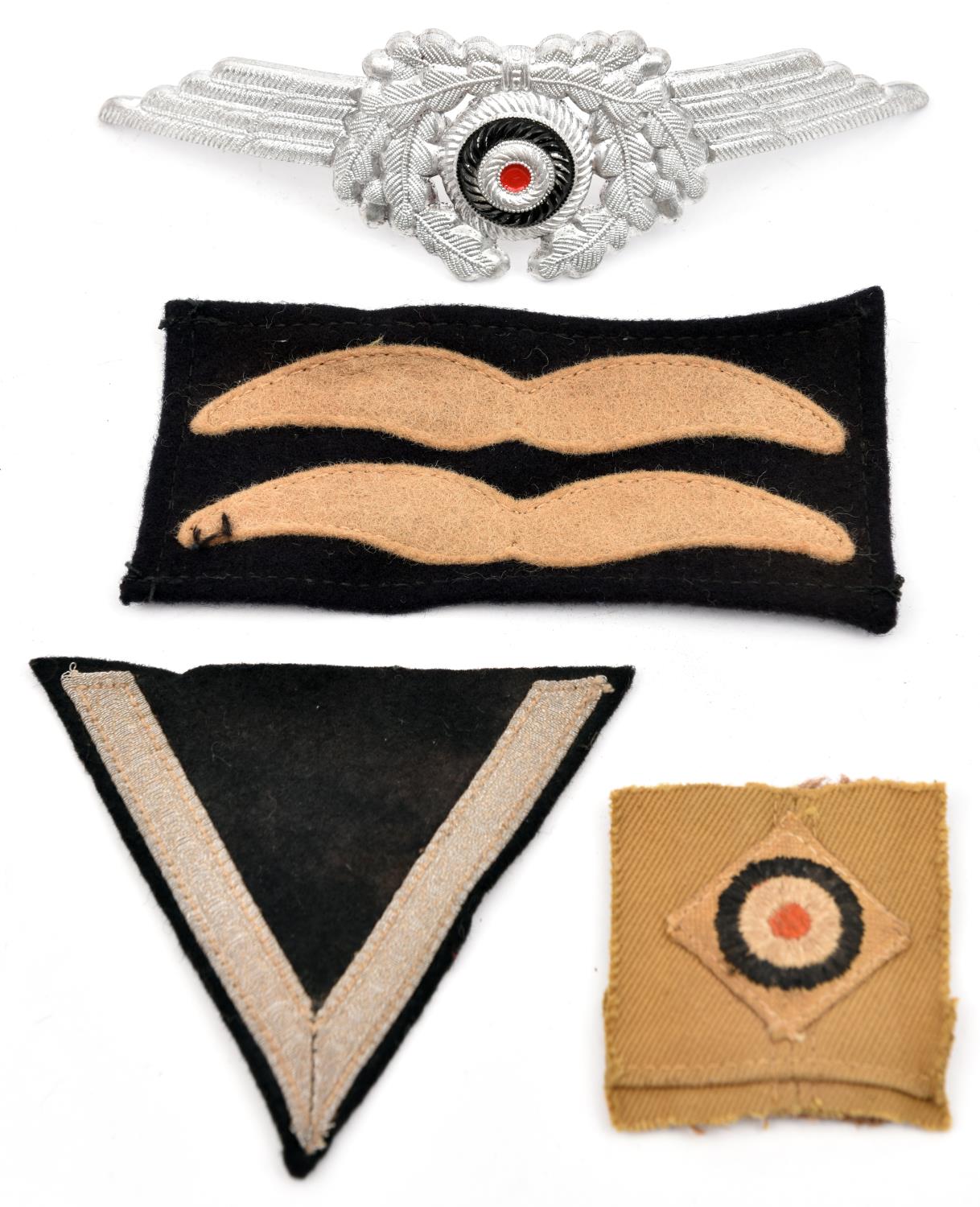 A Third Reich Luftwaffe NCOs aluminium winged cap cockade; an Afrikakorps embroidered cap cockade on