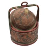 An African raffia woven circular basket, domed lid, stripwood carrying handle with central ring,