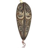 A New Guinea (Sepik River area) tear drop shaped wooden shield, carved and painted with a stylised