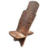 An African child's (?) chair, formed from 2 panels of wood which slot together in the centre, the