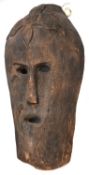 A large hollow, carved human head, in the form of a mask with cut out eyes, long nose and cut out